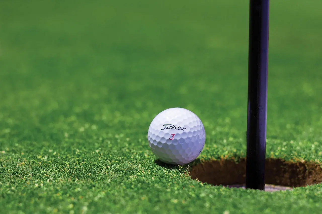 Golfbold ved hullet på putting green